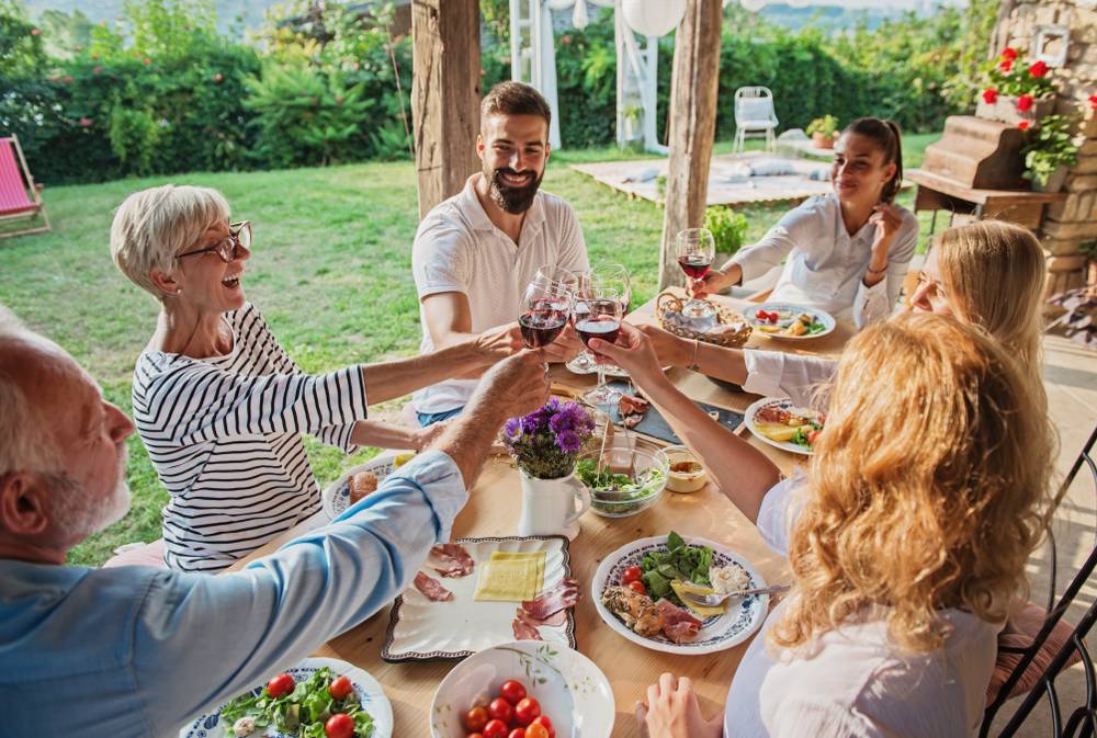 Family,Cheering,Over,The,Dining,Table,Outdoors,,Celebration